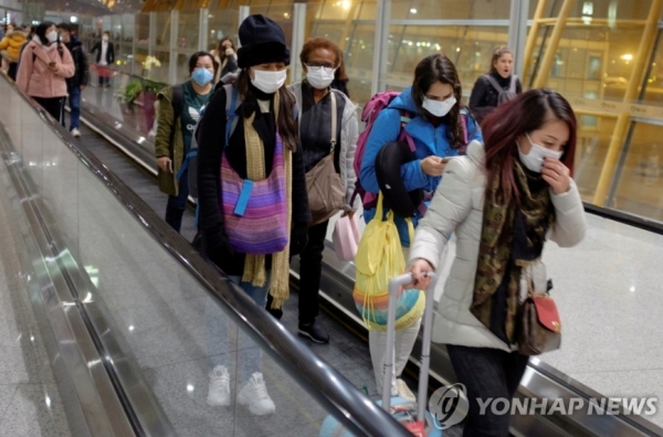 중국 베이징(北京) 서우두(首都) 국제공항에 도착한 여행객들이 마스크를 쓴 채 에스컬레이터를 타고 이동중이다. 사진=로이터/연합뉴스