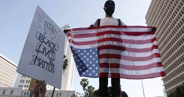 미국 캘리포니아 주 로스앤젤레스 검찰청사 앞에서 3일(현지시간) 평화시위에 참여한 시위대가 성조기를 거꾸로 들고 '흑인 사망' 항의 시위를 벌였다. 사진=AFP/연합뉴스
