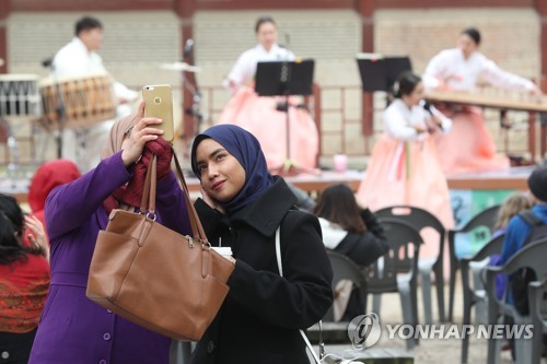 서울을 찾아 한국 문화를 즐기며 기념 사진을 찍고 있는 외국인들. 사진= 연합뉴스