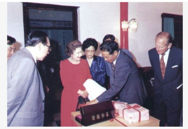 차 애호가인 영국의 엘리자베스2세가 쿤밍 방문중 진홍을 선물받고 있는 모습.