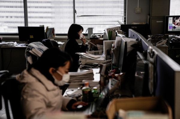 일본 경제산업성 사무실에서 직원들이 절전에 참여하기 위해 전등을 끈 채 일하고 있다. 지진에 이은 발전소 가동 중단과 추위 때문에 전력이 부족해지면서 22일 수도권과 도호쿠 지역에 전력 수급 위기 경보가 발령됐다. 사진=교도/연합