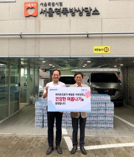 하이트진로 정세영 수석팀장(오른쪽)이 서울역 쪽방상담소 김갑록 소장에게 ‘건강한 여름나기’를 위한 석수를 전달했다.
