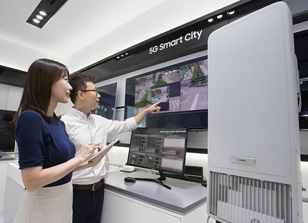 모델들이 5G 이동통신으로 스마트 시티 구현 가능성을 보여주는 '5G 커넥티비티 노드'를 시연하고 있다. 오른쪽이 3.5㎓ 대역 5G 장비. 삼성전자 제공