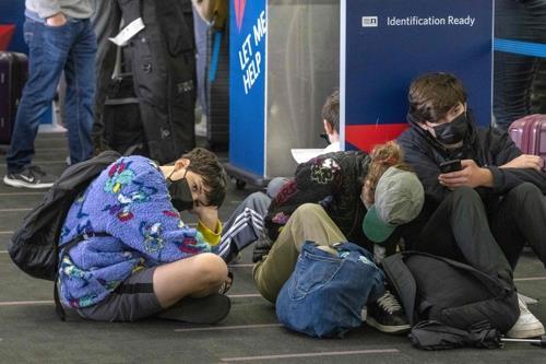 미국 로스앤젤레스국제공항에서 23일(현지시간) 여행자들이 델타항공 카운터 앞에 앉아있다. 사진=AFP/연합
